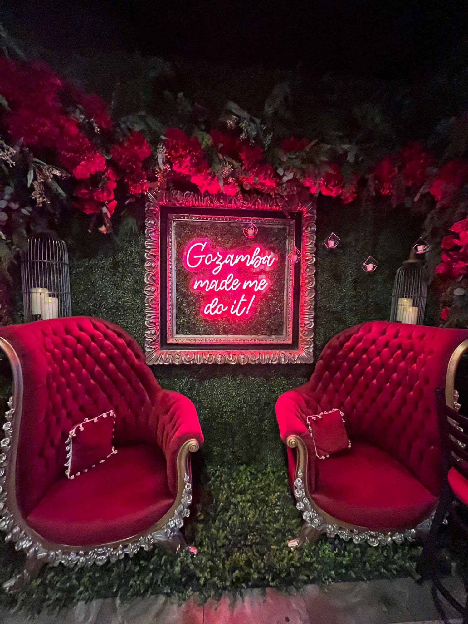 two red chairs with neon gozamba sign